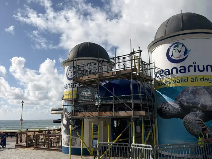 Access scaffold with mesh guards around the entrance of Bournemouth Oceanarium, between its two domed towers on Bournemouth seafront