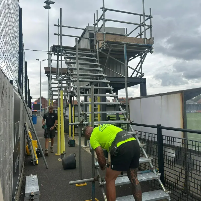 Up Top Scaffolding team installing a scaffold staircase to a viewing platform at Wimborne Town FC for AFC Bournemouth